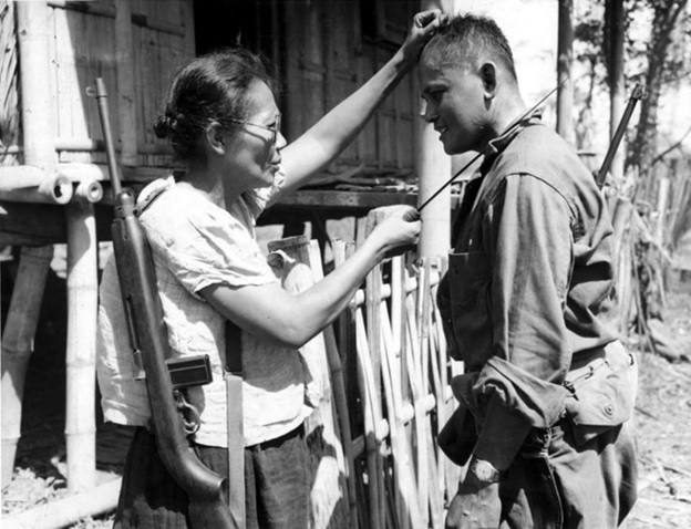 Captain Nieves  Fernandez, with a brand new .30 cal.  M1 Carbine and a sharp bolo, shows US Army Pvt. Andrew Lupiba how she used her long knife to silently kill Japanese soldiers during the Japanese occupation of Leyte Island. Image taken by Stanley Troutman on 7 November 1944, at Mabuhay Las Piñas, Leyte Island, Philippines.